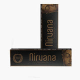 Black rectangular packaging of Koya’s Nirvana incense sticks, featuring bronze lettering with the word “Nirvana” and an image of a serene Buddha face. Two boxes are shown, one standing upright and one lying flat.