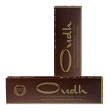 Brown rectangular packaging of Koya’s Oudh incense sticks, showing gold lettering that reads “Oudh Premium Incense Sticks” with a tagline about natural fragrance bringing upliftment and ease to mind. Two boxes are displayed, one standing upright and one lying flat.