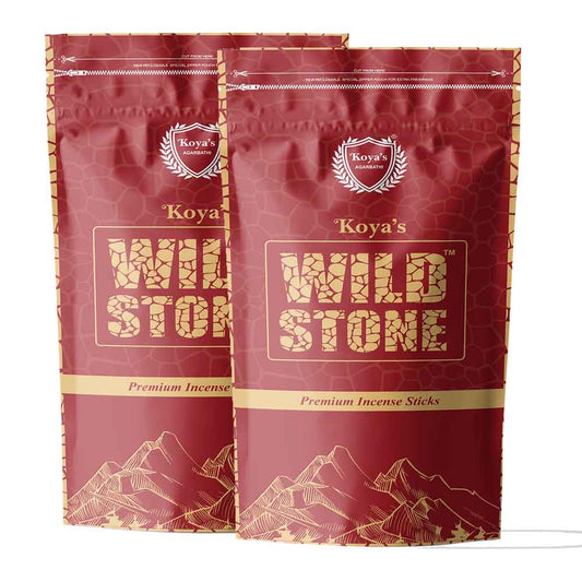 Two pouches of Koya's Wild Stone premium incense in a deep red zipper pouch with a subtle stone pattern. The packaging features the Koya's Agarbathi crest, the brand name in a rugged textured font, and a gold line-art illustration of a mountain range.