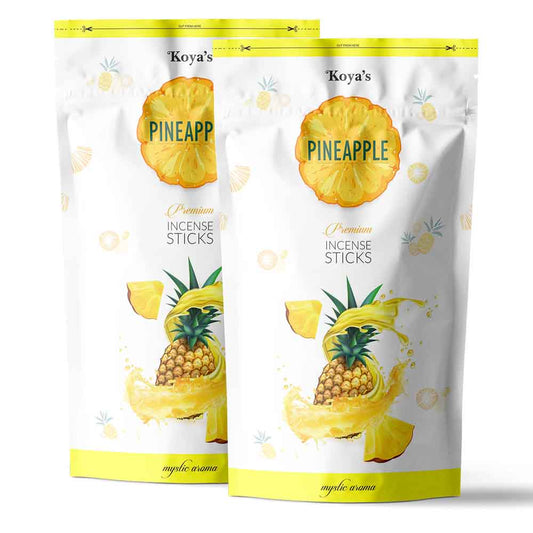 Two pouches of Koyas pineapple incense sticks in a white and yellow resealable zipper pouch. The packaging features a vibrant illustration of a pineapple splashing in juice and describes the scent as a 'mystic aroma'.